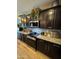 Close-up view of the kitchen featuring dark cabinets, stone countertops, and stainless steel appliances at 41143 W Rio Bravo Dr, Maricopa, AZ 85138