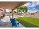 Backyard with artificial turf, a pebble surround, mature landscaping, covered patio and a refreshing pool at 4346 E Prickly Pear Trl, Phoenix, AZ 85050