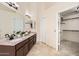 Bright bathroom featuring double vanity with granite counters and a walk-in closet for ample storage at 4346 E Prickly Pear Trl, Phoenix, AZ 85050