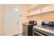 Laundry room with stainless steel washer and dryer, white shelves and a door leading to the garage at 4346 E Prickly Pear Trl, Phoenix, AZ 85050