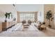 Inviting living room with plantation shutters, neutral paint, modern furnishings, and neutral carpet at 4346 E Prickly Pear Trl, Phoenix, AZ 85050