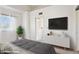 Airy bedroom with a large window, a flat screen TV, and minimalist white dresser for storage at 510 N Alma School Rd # 139, Mesa, AZ 85201