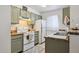 Charming kitchen with sage green cabinetry, white appliances, warm countertops, and a bright window with soft, sheer curtains at 510 N Alma School Rd # 139, Mesa, AZ 85201