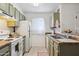Well-lit kitchen featuring modern sage green cabinetry, bright white appliances, and a window for ample natural light at 510 N Alma School Rd # 139, Mesa, AZ 85201