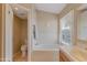 Bright bathroom featuring a soaking tub with natural light and neutral color scheme at 510 W Marconi Ave, Phoenix, AZ 85023