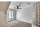 This bedroom features a ceiling fan, neutral carpet, window with blinds, and a unique glass block wall feature at 5729 S 21St Ter, Phoenix, AZ 85040