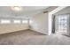 Bright bonus room featuring neutral carpet, a door to a balcony, and multiple horizontal windows at 5729 S 21St Ter, Phoenix, AZ 85040