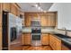Well-equipped kitchen with stainless steel appliances, wooden cabinets, and granite countertops at 5729 S 21St Ter, Phoenix, AZ 85040