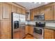 This eat-in kitchen features wood cabinets, stone countertops, and stainless-steel appliances at 5729 S 21St Ter, Phoenix, AZ 85040
