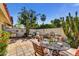 Charming patio area featuring a dining table, lounge chairs, and lush landscaping for outdoor enjoyment at 5738 N Scottsdale Rd, Scottsdale, AZ 85253