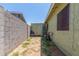Narrow backyard with a block wall, shed, ladder, and gardening equipment at 6014 W Evans Dr, Glendale, AZ 85306