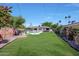 Expansive backyard featuring a lush lawn, sparkling pool, and charming landscaping at 609 E Winter Dr, Phoenix, AZ 85020