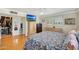 Bright bedroom featuring a floral comforter, wood floors, ceiling fan, television, and an organized closet at 609 E Winter Dr, Phoenix, AZ 85020