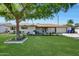 Charming single-story home with a well-manicured lawn, mature tree, and cozy front porch at 609 E Winter Dr, Phoenix, AZ 85020
