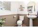 Charming half-bath featuring beadboard paneling, modern fixtures and stylish decorative shelving at 6343 W Sophie Ln, Laveen, AZ 85339