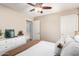 Bright bedroom with a comfortable bed, warm lighting, wood-look flooring, and ensuite bathroom at 6343 W Sophie Ln, Laveen, AZ 85339