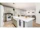 Bright kitchen with a large island, farmhouse sink, white cabinets, and stainless-steel appliances at 6343 W Sophie Ln, Laveen, AZ 85339