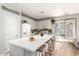 Stylish kitchen featuring a large island with bar seating, white cabinets, and modern lighting at 6343 W Sophie Ln, Laveen, AZ 85339