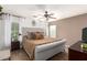 Bright main bedroom with plush bed, ceiling fan, wood-look floors, and stylish decor at 6343 W Sophie Ln, Laveen, AZ 85339