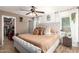 Bright main bedroom with plush bed, ceiling fan, wood-look floors, and access to ensuite at 6343 W Sophie Ln, Laveen, AZ 85339