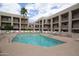 Resort-style pool with lounge chairs and a palm tree under a partly cloudy sky at 7474 E Earll Dr # 201, Scottsdale, AZ 85251