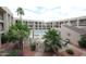 Community pool and spa surrounded by lush landscaping and condo buildings at 7474 E Earll Dr # 201, Scottsdale, AZ 85251