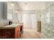 Bright bathroom featuring dual sinks, a glass block shower, and a tiled floor at 808 N 78Th St, Scottsdale, AZ 85257