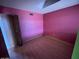 Small bedroom featuring pink walls, wood-look floors, and a closet space at 836 W Laguna Azul Ave, Mesa, AZ 85210