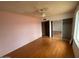 Bedroom featuring pink walls, wood-look floors, ceiling fan, a large window, and a closet at 836 W Laguna Azul Ave, Mesa, AZ 85210