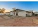 A spacious backyard features a brick patio, white stucco walls, and minimal landscaping under a vibrant blue sky at dusk at 8717 W Turney Ave, Phoenix, AZ 85037