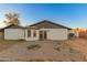 A white home with a brick patio leads to glass doors and a bay window under a gray roof against a clear blue sky at 8717 W Turney Ave, Phoenix, AZ 85037
