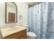 Well-lit bathroom featuring a single sink vanity, toilet, and seashell-themed shower curtain at 8717 W Turney Ave, Phoenix, AZ 85037