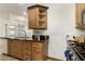 Kitchen area with open shelving, wood cabinets with black countertops, and tile floors at 8717 W Turney Ave, Phoenix, AZ 85037