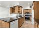 Kitchen area featuring wood cabinets with black countertops, open shelving and stainless steel appliances at 8717 W Turney Ave, Phoenix, AZ 85037