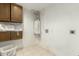 Functional laundry room with tile floors, storage cabinets, and a modern water heater at 8717 W Turney Ave, Phoenix, AZ 85037