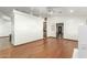 Large room with hardwood floors, a decorative wall, and openings to the kitchen and hallway at 8717 W Turney Ave, Phoenix, AZ 85037