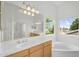 Bright bathroom featuring dual sinks, a garden tub, and a window with backyard views at 8754 W Karen Lee Ln, Peoria, AZ 85382