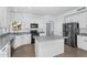 The light and bright kitchen features white cabinets, an island, and stainless steel appliances at 8754 W Karen Lee Ln, Peoria, AZ 85382