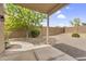 Covered patio area overlooking a backyard with desert landscaping and mature trees at 8754 W Karen Lee Ln, Peoria, AZ 85382