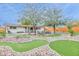 Beautifully landscaped backyard with artificial turf, mature trees, putting green and brick pavers at 8930 W Sells Dr, Phoenix, AZ 85037