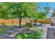 Landscaped backyard featuring a seating area and mature trees providing ample shade at 8930 W Sells Dr, Phoenix, AZ 85037