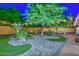 Wonderful backyard featuring a putting green, trees with string lights, and stone landscaping at 8930 W Sells Dr, Phoenix, AZ 85037