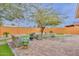 Landscaped backyard with patio featuring a cozy seating area with stone accents and lush green grass at 8930 W Sells Dr, Phoenix, AZ 85037