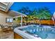 Backyard boasts hot tub, covered patio with a dining set, and trees with string lights at 8930 W Sells Dr, Phoenix, AZ 85037