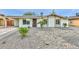 Well-maintained single-story home with desert landscaping, solar panels, and a cozy front entrance at 8930 W Sells Dr, Phoenix, AZ 85037