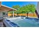 Relaxing backyard showcasing a hot tub, seating area, and mature trees offering privacy at 8930 W Sells Dr, Phoenix, AZ 85037
