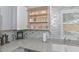 Kitchen detailing gray backsplash, granite countertops, filled cabinets, and a stainless sink at 8930 W Sells Dr, Phoenix, AZ 85037