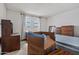Bedroom featuring two dressers, a bed, and a window-facing desk, with personal belongings packed in boxes at 10072 W Lancaster Dr, Sun City, AZ 85351