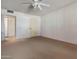 Bright bedroom featuring neutral carpet, ceiling fan and white walls with two entry doors at 10072 W Lancaster Dr, Sun City, AZ 85351