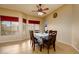 Bright dining room features tile flooring, a ceiling fan, and backyard views from the large windows at 10242 E Pantera Ave, Mesa, AZ 85212